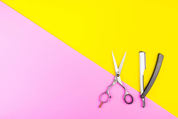 Stylish Professional Barber Scissors on yellow and pink backgrou - Fotó, kép