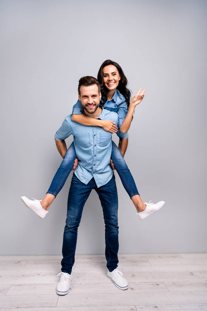 Full length vertical body size photo funky cheer she her he him his lady guy piggy-back ride adventures hand arm show v-sign say hi wear casual jeans denim shirts clothes isolated grey background - Foto, Bild