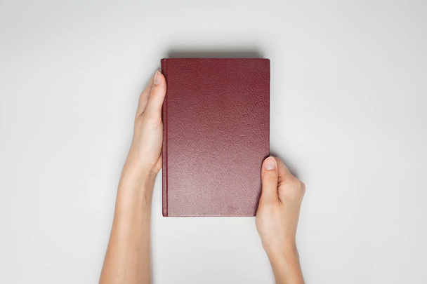 hands hold the red book(diary) cover isolated white. - Fotó, kép