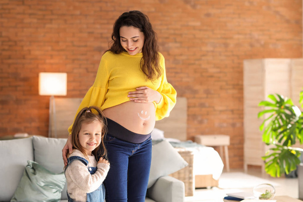Pregnant mother with little daughter at home - Fotoğraf, Görsel