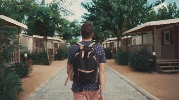 Yaz aylarında küçük ahşap evler kamp alanında adam gezinme arka görünümü - Video, Çekim