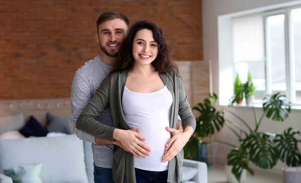 Portrét šťastného těhotného páru doma - Fotografie, Obrázek