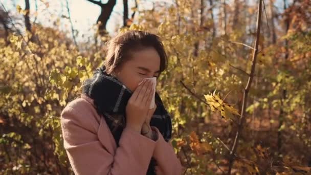 Allergiás lány az őszi erdőben. - Felvétel, videó