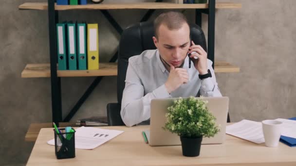 Young man talking on phone in office - Filmagem, Vídeo