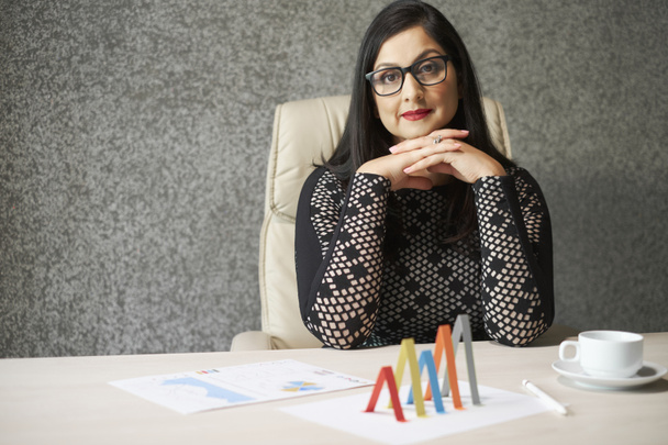 Ritratto di manager finanziaria donna professionista seduta a tavola con documenti finanziari sopra
  - Foto, immagini