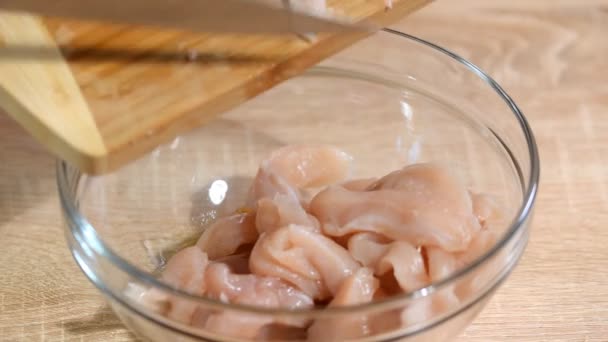Surowego kurczaka filety piersi pokroić w kawałki i przyprawione w szklanej misce. - Materiał filmowy, wideo