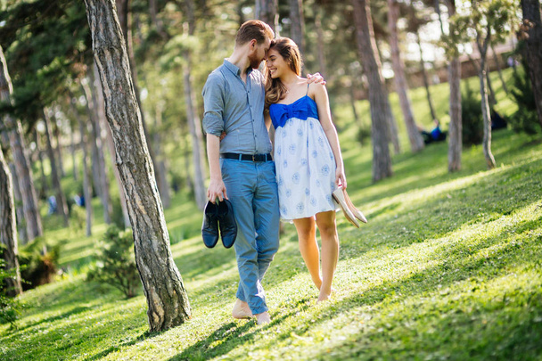 Beautiful couple in park taking a walk barefoot - Foto, Bild