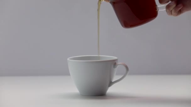 Frauenhände gießen einen Tee aus einem Wasserkocher in eine chinesische Tasse. Teezeremonie. Teil 54. - Filmmaterial, Video