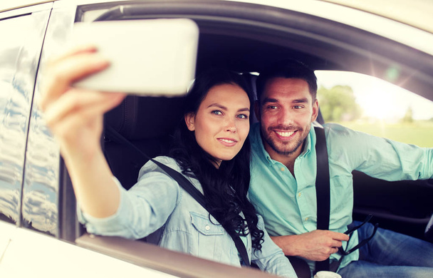 happy couple in car taking selfie with smartphone - Fotoğraf, Görsel