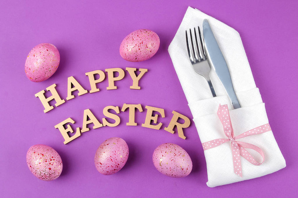 Великдень. Рожеві великодні яйця і ніж з виделкою. Пасхальний стіл. на модному фіолетовому фоні. Щасливого Великодня. канікули. вид зверху
 - Фото, зображення