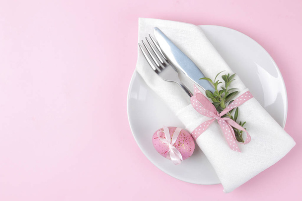 Velikonoce. Růžový velikonoční vajíčka a talíř, nůž a vidlička na módní růžové pozadí. Velikonoční prostírání. Veselé velikonoce. dovolená. pohled shora - Fotografie, Obrázek
