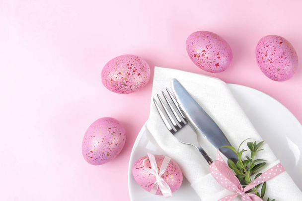 Πάσχα. Ροζ Πασχαλινά αυγά και πλάκα, μαχαίρι και πιρούνι σε ένα trendy ροζ φόντο. Ρύθμιση πίνακα Πάσχας. Καλό Πάσχα. διακοπές. το top view - Φωτογραφία, εικόνα