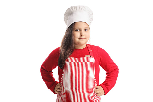 Little girl wearing apron and cooking hat isolated on white background - Photo, Image