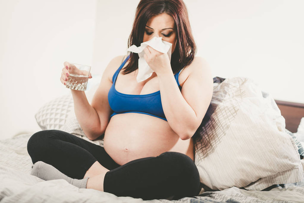 Pregnant woman blowing her nose - Zdjęcie, obraz