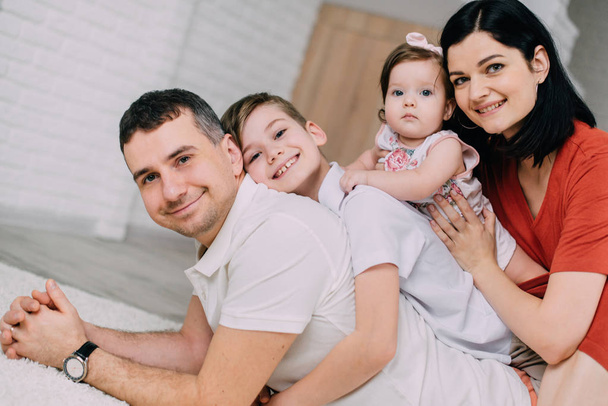 Fröhliches Porträt einer glücklichen jungen Familie zu Hause - Foto, Bild