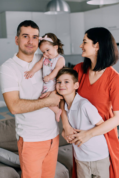 Nuori onnellinen perhe täysin seisoo kotona
 - Valokuva, kuva