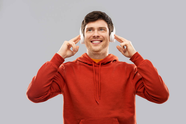 happy young man in headphones and red hoodie - Foto, Imagen