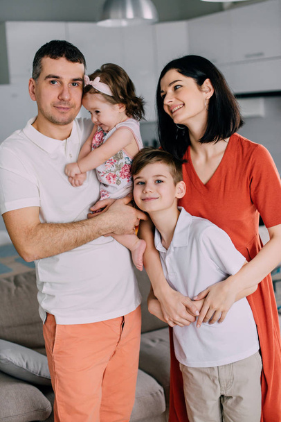 Young happy family in full standing at home - Foto, afbeelding