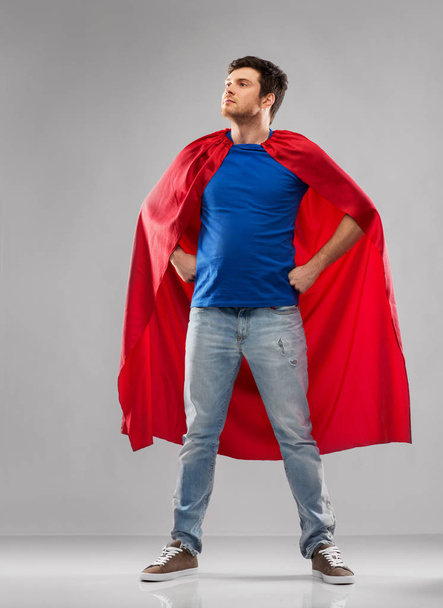 hombre en capa de superhéroe rojo sobre fondo gris
 - Foto, imagen
