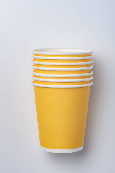 Жовті екологічні паперові чашки для вечірки на білому тлі
 - Фото, зображення