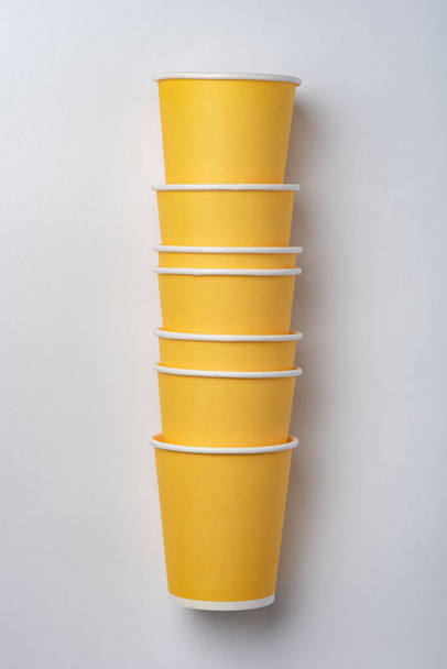 Tasses en papier jaune écologique pour une fête sur fond blanc
 - Photo, image