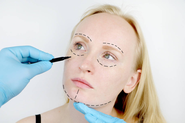 Cirurgia plástica facial ou facelift, facelift, correção facial. Um cirurgião plástico examina um paciente antes da cirurgia plástica
. - Foto, Imagem