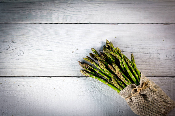 Healthy fresh green asparagus on wooden background - Foto, afbeelding