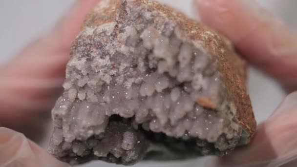 Bright grey ruby crystal ore in hands with gloves. Crystallization is the natural or artificial process by which a solid forms in laboratory. - Footage, Video