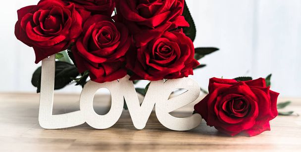 Ahşap aşk yazı ile güzel çiçekler. Aşk kavramı. - Fotoğraf, Görsel