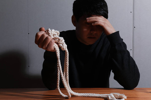 Depressed man with rope thinking about suicide at home - Photo, Image