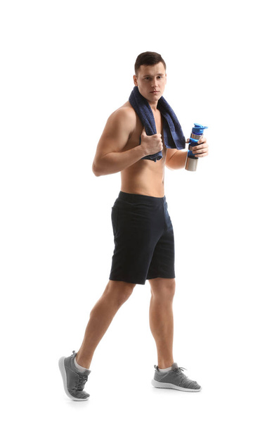 Спортивний молодий чоловік з пляшкою води на білому тлі
 - Фото, зображення