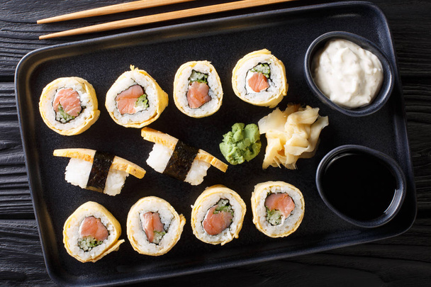 rollo de sushi en la tortilla con arroz, queso, salmón y aguacate
 - Foto, Imagen