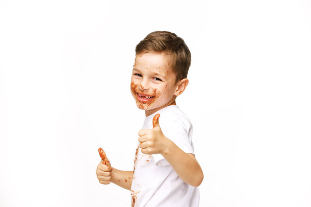 little boy with face and hands in chocolate  - Foto, Imagem