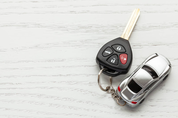 Car keys with remote control security and car key chain on white wooden background. Copy space for text - Photo, Image