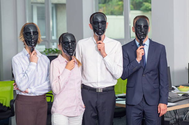 Group of four office employees with closed black face masks. Without a personal staff. People hypocrisy concept. - Foto, imagen