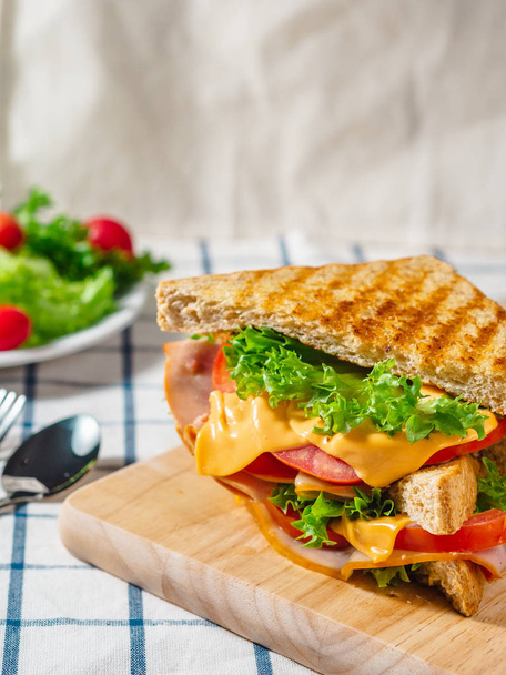 Primo piano di Sandwich con prosciutto, formaggio, pomodori, lattuga, e per - Foto, immagini