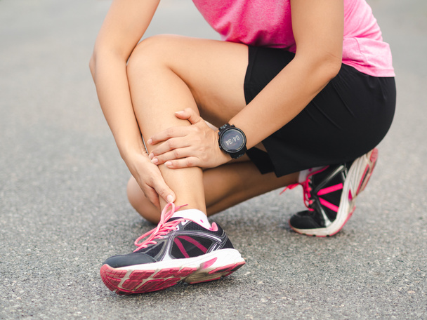 Αθλητής γυναίκα έχει τραυματισμό στον αστράγαλο, διάστρεμμα στο πόδι κατά τη διάρκεια της λειτουργίας trai - Φωτογραφία, εικόνα