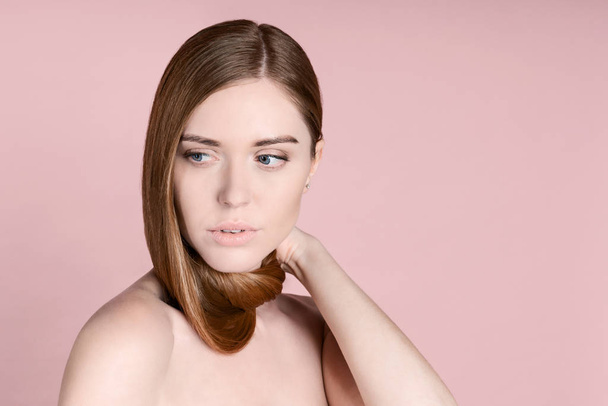 Portrait of attractive young woman looking away with hair on her neck over pink background - Foto, Imagem