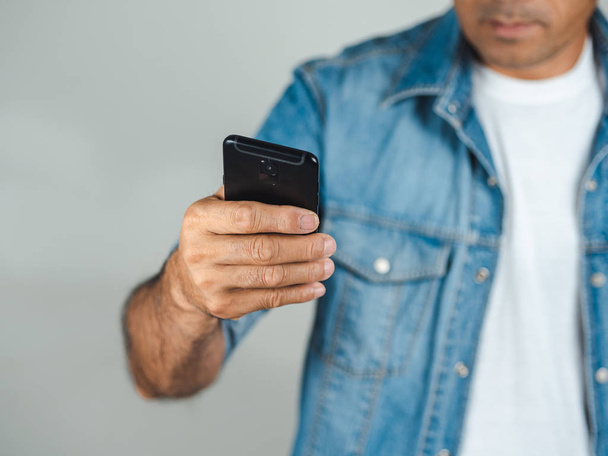 Detailní záběr mladého muže pomocí smartphone izolované na bílém backgr - Fotografie, Obrázek