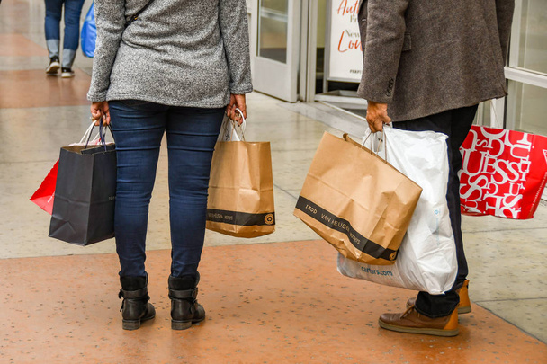 LAS VEGAS, NV, USA - FEBRUARY 2019: People with carrier bags of purchases after shopping in the Simon Premium Outlets north in Las Vegas. - Foto, imagen