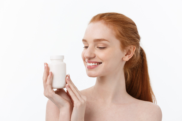 Muotokuva hyvännäköinen nuori valkoihoinen nainen pillerit, yrittää huolehtia immuunijärjestelmän ja terveyden yli harmaa tausta
. - Valokuva, kuva