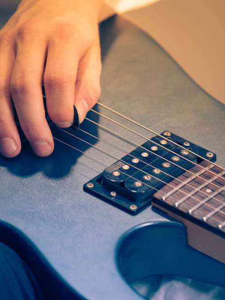 Close up of man playing on electric guitar - Foto, afbeelding