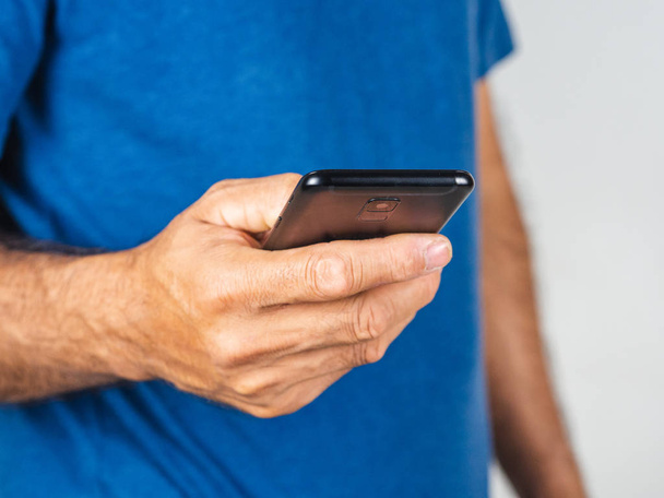 Szoros kép a fiatal férfi használ okostelefon elszigetelt egy fehér backgr - Fotó, kép