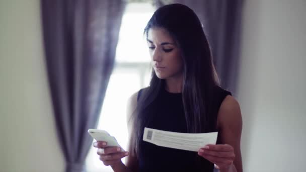 Young businesswoman on a business trip in a hotel room, using smartphone. - Záběry, video