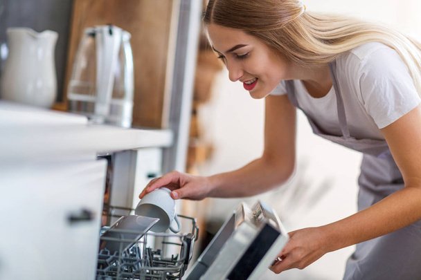 Nainen tiskaamassa astianpesukoneessa - Valokuva, kuva