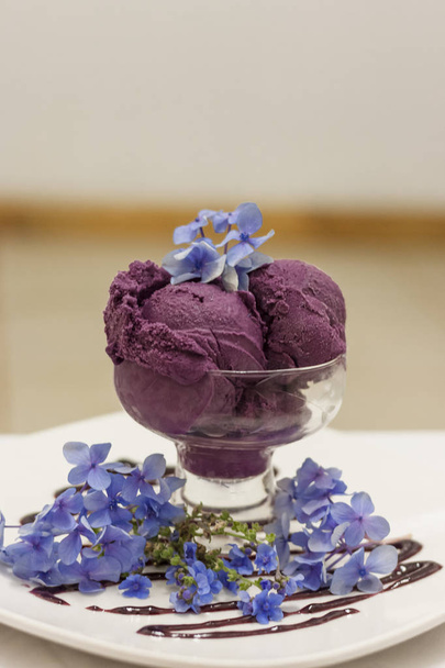 Deep purple ice cream scoops decorated with fancy flowers - Photo, Image