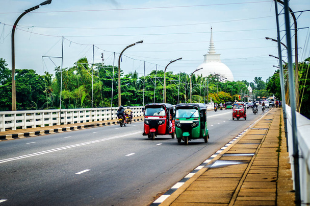Різнокольорові тук тук їзда на дорозі від Калутара на тлі буддійського храму. Шрі-Ланка - Фото, зображення