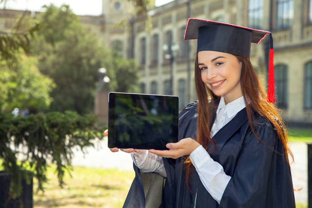 Woman on her graduation day. Use tablet pc. University, education, digital technology and happy people - concept. - Foto, Imagen