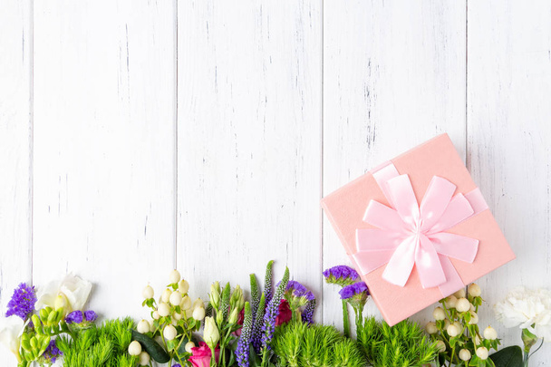 Background with spring flowers and pink gift box - Photo, Image