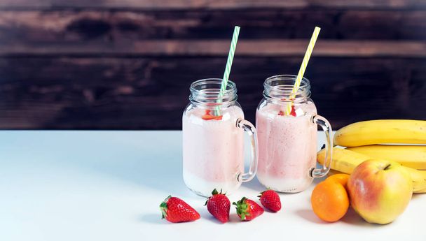 Joghurt üvegedényekben gyümölcsökkel az asztalon - Fotó, kép